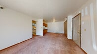 This single-floor unit at 155 Memorial Dr in Sturgis, Michigan offers a practical and comfortable layout designed for everyday living. The open living area is generously sized, featuring warm neutral carpet, a textured ceiling, and a sliding glass door that invites natural light and provides access to an outdoor space with views of the surrounding grounds. A baseboard heating system runs throughout the unit, ensuring consistent warmth. The kitchen is laid out in a galley style, lined with white cabinetry accented by wood trim on both sides, offering ample storage and counter space. It is equipped with a white electric range, refrigerator, dishwasher, and a stainless steel sink. A pass-through counter connects the kitchen to the living and dining area, enhancing the open feel of the space. The bedroom features plush carpet flooring, multiple windows that bring in natural light and outdoor views, and a full-width closet with bi-fold doors and a built-in rod and shelf for organized storage. The bathroom is finished with light tile flooring, a wide vanity with a single sink, and accessibility-oriented features including a grab bar near the toilet. The clean, neutral palette throughout the unit provides a versatile and move-in-ready living environment.