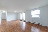 Located at 1580 Adelaide St N in London, Ontario, this 2-bedroom, 1-bathroom unit offers a well-organized and efficient layout across a single floor. The entry foyer welcomes you with light tile flooring and immediate access to a closet, setting a clean and functional tone for the rest of the space.

The living room is a generous, open area featuring warm-toned hardwood flooring that continues throughout the unit, bright white walls, and a large window that invites natural light and offers pleasant outdoor views of the surrounding greenery. The space flows directly into the kitchen, which is equipped with stainless steel appliances including a refrigerator and electric range, white cabinetry, a tile backsplash, and tile flooring underfoot.

Both bedrooms are well-proportioned and share the same warm hardwood flooring and clean white walls. The primary bedroom features a large sliding window with outdoor views, a baseboard heating unit, and ample room for furnishings. The second bedroom is similarly bright, with a window providing natural light.

The bathroom is neatly finished with tile flooring, a white vanity with under-sink storage, a full soaker tub with a tiled surround accented by a decorative border, and a chrome shower fixture. The overall aesthetic throughout the unit is clean, bright, and move-in ready.