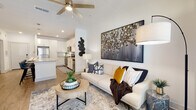Located at 10491 Gandy Blvd N in Saint Petersburg, FL, this single-floor residence offers a well-designed open-concept layout that seamlessly connects the kitchen, dining, and living areas. The kitchen is equipped with stainless steel appliances, white shaker cabinetry extending to the ceiling, a subway tile backsplash, and granite countertops that continue onto a spacious island with bar seating — ideal for both everyday meals and entertaining. Wood-look flooring flows throughout the main living areas, while ceiling fans contribute to the light, airy ambiance. The living area benefits from natural light through large windows dressed with floor-length drapes, with access to a private balcony. The bedrooms feature plush carpeting and large windows, with one bedroom offering a pool view. Bathrooms are finished with granite-topped vanities, white cabinetry, and wood-look flooring. A dedicated in-unit laundry room with a full-size washer and dryer adds everyday convenience. Throughout the space, clean white walls and modern finishes create a bright, contemporary atmosphere that is both functional and inviting.