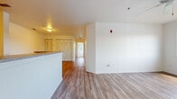 Located at 1793 Mission Bay Cir in Rockledge, Florida, this single-story home offers a practical and well-organized layout across three bedrooms and two bathrooms. The interior design is clean and neutral throughout, with white walls and white trim creating a bright, cohesive aesthetic.

The living area features light wood-look vinyl flooring and a ceiling fan, with large windows that invite generous natural light and outdoor views of surrounding greenery. An adjacent kitchen is efficiently arranged in a galley style, outfitted with warm-toned wood cabinetry, dark countertops, white appliances including a range and refrigerator, and matching wood-look flooring that continues the open feel.

The bedrooms are finished with neutral carpet and ceiling fans, each receiving ample natural light through large windows. The primary bedroom includes a walk-in closet equipped with wire shelving for organized storage. Additional bedrooms are similarly carpeted and well-lit, offering flexible use.

The bathrooms feature clean white tile surrounds with a full bathtub and shower combination. A hallway with built-in closet doors provides additional storage. Overall, the home presents a straightforward, functional living environment suited to comfortable everyday use.