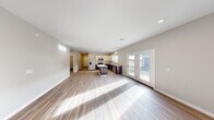Located at 5999 Paradise Circle Rd in Saginaw, Michigan, this well-appointed single-story home features a thoughtfully designed layout with three bedrooms, two bathrooms, and a spacious attached garage. The open-concept living room and kitchen area form the heart of the home, showcasing wood-look luxury vinyl plank flooring, recessed lighting, and an abundance of natural light. French doors lead to the outdoors, enhancing the bright and airy atmosphere. The kitchen is equipped with stainless steel appliances, a central island with dark cabinetry, contrasting white upper cabinets, granite-look countertops, and a stainless steel sink beneath a window. The generous living area flows seamlessly from the kitchen, providing an ideal space for entertaining. The primary bedroom offers a comfortable footprint with a walk-in closet featuring wire shelving. Additional bedrooms are served by well-placed hallways and include windows with outdoor views. A dedicated laundry room with washer hookups adds everyday convenience. The hallways are finished with elegant arched panel doors and matte black hardware, lending a modern touch throughout. The attached garage features a clean concrete floor and overhead lighting, offering ample storage or parking space.