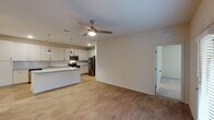 This well-appointed 3-bedroom, 2-bathroom single-story home offers a thoughtfully designed layout with modern finishes throughout. The open-concept living and kitchen area serves as the heart of the home, featuring warm wood-look flooring, a ceiling fan with light fixture, and seamless flow between spaces. The kitchen is outfitted with stainless steel appliances — including a range, microwave, dishwasher, and refrigerator — complemented by granite countertops, a classic subway tile backsplash, and ample white cabinetry that extends to the ceiling for generous storage. A peninsula provides additional prep and dining space.

The bedrooms are carpeted for comfort, with the primary suite offering a walk-in closet equipped with wire shelving. The primary bathroom features a granite-topped vanity with an undermount sink and wood-look flooring. The secondary bathroom includes a tiled tub-and-shower combination with brushed nickel fixtures and granite countertops.

A dedicated laundry closet houses a full-size washer and dryer. The home also includes an electrical panel conveniently located in the hallway. Neutral tones and clean lines throughout create a bright, welcoming ambiance suited to a variety of lifestyles.