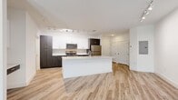 Located at 1659 2nd St in Sarasota, FL, this modern one-bedroom, one-bathroom residence offers a thoughtfully designed open-concept layout with contemporary finishes throughout. Light-toned wood-look flooring flows seamlessly through the main living areas, complemented by crisp white walls and track lighting that enhances the bright, airy ambiance.

The kitchen serves as the centerpiece of the home, featuring a large island with a quartz countertop and an undermount sink, dark espresso cabinetry contrasted by white upper cabinets, and a full suite of stainless steel appliances including a range, microwave, dishwasher, and refrigerator. The kitchen opens directly into the living area, which benefits from a large window that draws in natural light and provides views of the surrounding neighborhood.

The bedroom is a comfortable, carpeted retreat with direct access to the full bathroom. The bathroom is elegantly appointed with large-format stone-look tile flooring, an elongated dual-sink vanity with quartz countertops, and a generous walk-in closet equipped with extensive wire shelving and hanging rods, offering ample storage. Clean lines and a neutral palette throughout create a cohesive, modern aesthetic ideal for Sarasota living.