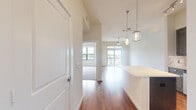 Located at 1235 Nasa Pkwy in Houston, TX, this one-bedroom, one-bathroom residence offers a well-designed single-floor layout that makes efficient use of its space. The open-concept kitchen and living area serves as the heart of the home, featuring rich hardwood-style flooring, dark espresso cabinetry with ample storage, and a sleek white kitchen island. Stainless steel appliances — including a gas range, over-the-range microwave, and French door refrigerator — are complemented by granite countertops and a classic subway tile backsplash. Geometric pendant lights add a modern touch overhead. The living area extends to a private balcony through sliding glass doors, filling the space with natural light and outdoor views. A ceiling fan enhances comfort throughout. The bedroom is a well-proportioned retreat finished with plush carpet, a ceiling fan, and a large window that brings in natural light. It connects directly to a spacious walk-in closet with wire shelving on multiple walls. The bathroom is elegantly appointed with large-format marble-look tile, a glass-enclosed walk-in shower, granite vanity countertop, and clean, neutral finishes throughout.