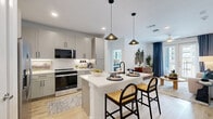 Located at 541 J Pl in Plano, TX, this thoughtfully designed 2-bedroom, 3-bathroom residence offers a comfortable and modern living experience across a single floor. Light wood flooring flows throughout the main living areas, creating a warm and cohesive aesthetic.

The open-concept kitchen is a standout feature, equipped with gray shaker-style cabinetry, white quartz countertops, a subway tile backsplash, stainless steel appliances, and a central island with pendant lighting and seating — ideal for both cooking and casual dining.

The living room is bright and inviting, benefiting from large French doors that open to an outdoor balcony and allow generous natural light to pour in. The space is complemented by a ceiling fan and clean, neutral walls.

The primary bedroom is a spacious retreat with large windows offering outdoor views, plush carpeting, and direct access to a private en-suite bathroom. The bathroom features a soaking tub with marble-style tile surround, a gray vanity with a framed mirror, and light wood flooring. A walk-in closet with built-in shelving and dual hanging rods adds practical storage.

The second bedroom is equally well-lit with large windows and carpeted flooring. Each room reflects a clean, contemporary design with a neutral palette that enhances the sense of openness throughout the home.