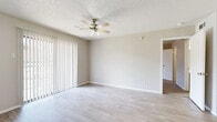 This single-floor, one-bedroom, one-bathroom unit offers a thoughtfully designed layout that maximizes every square foot of its compact footprint. The living area greets residents with light wood-look flooring, neutral gray-toned walls, and a ceiling fan with integrated lighting overhead. A textured ceiling adds dimension, while large vertical blinds along a sliding door panel allow natural light to fill the space and provide an easy connection to the outdoors.

The galley-style kitchen is a functional highlight, featuring gray cabinetry with ample upper and lower storage, white countertops, a double-basin sink, and a stylish mosaic tile backsplash in earthy tones. Black appliances—including a refrigerator, stove, and over-the-range microwave—complement the contemporary color palette, while light wood-look flooring ties the space together seamlessly.

The bedroom is carpeted for comfort and includes a ceiling fan, a large window fitted with horizontal blinds, and dedicated closet space. Neutral walls and clean white trim throughout maintain a cohesive, move-in-ready aesthetic.

The bathroom is neatly appointed with light wood-look flooring, a vanity with under-sink cabinetry, a tub-shower combination, and clean white fixtures. A dedicated closet rounds out the unit's storage offerings, ensuring practical, everyday convenience.