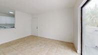 Located at 7050 Northwest 179th Street in Hialeah, FL, this single-floor residence offers three bedrooms and two bathrooms within a thoughtfully arranged floor plan. The layout includes a living room, a hallway, a closet, and well-proportioned bedroom spaces, all unified by light beige ceramic tile flooring that runs consistently throughout the home.

The living room is a bright, open space anchored by large sliding glass doors that lead to a balcony, framing views of mature trees and the surrounding neighborhood. Natural light fills the room, enhancing the clean, white walls and creating an airy atmosphere.

The three bedrooms maintain the same light tile flooring and white walls, with windows that bring in natural light and outdoor greenery views. The primary bedroom offers a comfortable footprint with ample wall space. The additional bedrooms are similarly designed, providing functional and versatile spaces.

The two bathrooms feature white cabinetry with marble-patterned countertops, a large mirror with overhead lighting, and a full bathtub with marble-style tile surround and chrome fixtures — lending a clean, polished look. Central air conditioning vents are present throughout, ensuring year-round comfort. The overall aesthetic is bright, minimal, and move-in ready.
