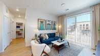 This single-story residence in Aurora, Colorado, offers a thoughtfully organized layout that maximizes its compact footprint. The open-concept living room and kitchen serve as the heart of the home, where light hardwood-style flooring, crisp white walls, and a large sliding glass door create a bright, airy atmosphere with views to the outdoors. The living area provides comfortable room for seating and entertainment, benefiting from natural light that flows in through the generous glazed door and surrounding windows.

The kitchen is finished to a modern standard, featuring floor-to-ceiling shaker-style cabinetry in a soft gray tone, white quartz countertops, a classic subway tile backsplash, and a full suite of stainless steel appliances including a range, built-in microwave, and side-by-side refrigerator. A kitchen island adds additional counter space and functionality.

The bedroom is a well-proportioned private retreat carpeted for comfort, featuring a ceiling fan, large windows dressed with blackout curtains, and wall space suited for storage shelving. A dedicated closet completes the room. Throughout the residence, clean finishes and a neutral palette contribute to a cohesive, contemporary ambiance.