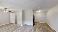 Located at 5600 E 84th Ter in Kansas City, Missouri, this efficient single-floor unit offers a practical and thoughtfully arranged layout. The space features durable wood-look plank flooring throughout, lending a clean and contemporary aesthetic to every room.

The open living area is bright and simply designed, with neutral gray walls, white baseboards, and a ceiling fan with integrated lighting that provides both comfort and illumination. A window fitted with blinds allows natural light to filter in, while a wall-mounted air conditioning unit ensures year-round climate control. The entry door opens directly into this main living space, creating an accessible and straightforward flow.

The kitchen area is positioned adjacent to the living space and is equipped with white cabinetry, a refrigerator, and a stove, offering functional cooking amenities. A bathroom with a vanity and fixtures is also accessible from the main living area.

A dedicated closet provides convenient storage space. The unit also benefits from access to a landscaped outdoor walkway area, framed by mature trees and greenery, adding a pleasant natural backdrop to the property.

The overall ambiance is clean, modern, and move-in ready, making this a practical and efficient space located in a well-established Kansas City neighborhood.