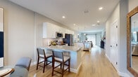 Located at 6 Crossgates Rd in Albany, NY, this well-appointed two-story home offers three bedrooms, two full bathrooms, and a thoughtfully designed layout spread across two floors. The main floor hosts the majority of the living space, featuring an open-concept kitchen, dining, and living area finished with light hardwood flooring throughout. The kitchen is equipped with white shaker cabinetry, granite countertops, a subway tile backsplash, stainless steel appliances, and a center island with bar seating and pendant lighting. It flows seamlessly into the dining area, which benefits from large windows that bring in natural light, and the living room, which features recessed lighting and a sliding glass door with outdoor views. The two bathrooms are finished with granite vanities and clean, neutral tiling. Bedrooms are generously sized, with the primary suite offering a walk-in closet fitted with wire shelving systems. The upper floor provides additional bedroom space. Two closets and a hallway add practical storage throughout. The attached garage offers additional utility space. Neutral tones, recessed lighting, and consistent flooring create a cohesive, modern ambiance throughout the home.