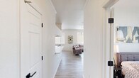 This well-appointed 2-bedroom, 1-bathroom residence in Phoenix, AZ offers a clean, modern aesthetic throughout its single-floor layout. Light wood-style flooring flows continuously across all rooms, creating a cohesive and airy feel.

The living room is a bright, welcoming space featuring a ceiling fan, large windows with vertical blinds that invite abundant natural light, and a sliding glass door that opens directly to a private outdoor patio — ideal for enjoying the Arizona climate.

The galley-style kitchen is efficiently designed with white cabinetry accented by dark hardware, a double-basin sink, and a full suite of stainless steel appliances including a refrigerator, electric range, and microwave. A hallway connects the main living areas to the private quarters.

The spacious primary bedroom includes a ceiling fan, large windows with outdoor views, and a closet. A second bedroom offers a window with natural light, providing a comfortable and functional space suitable as a guest room or home office.

The shared bathroom features a white vanity with a wide mirror, matte black fixtures, and a shower/tub combination. Throughout the residence, the white walls and consistent flooring contribute to a bright, clean, and modern atmosphere.