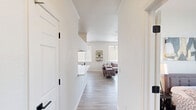 This well-appointed 2-bedroom, 1-bathroom residence in Phoenix, AZ offers a clean, modern aesthetic throughout its single-floor layout. Light wood-style flooring flows continuously across all rooms, creating a cohesive and airy feel.

The living room is a bright, welcoming space featuring a ceiling fan, large windows with vertical blinds that invite abundant natural light, and a sliding glass door that opens directly to a private outdoor patio — ideal for enjoying the Arizona climate.

The galley-style kitchen is efficiently designed with white cabinetry accented by dark hardware, a double-basin sink, and a full suite of stainless steel appliances including a refrigerator, electric range, and microwave. A hallway connects the main living areas to the private quarters.

The spacious primary bedroom includes a ceiling fan, large windows with outdoor views, and a closet. A second bedroom offers a window with natural light, providing a comfortable and functional space suitable as a guest room or home office.

The shared bathroom features a white vanity with a wide mirror, matte black fixtures, and a shower/tub combination. Throughout the residence, the white walls and consistent flooring contribute to a bright, clean, and modern atmosphere.