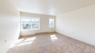 Located at 319 N I St in Tacoma, WA, this one-bedroom, one-bathroom unit offers a thoughtfully laid-out single-floor plan with a clean, bright aesthetic. The open living area is finished with plush wall-to-wall carpeting and crisp white walls, creating a welcoming and airy atmosphere. A pair of large windows floods the space with natural light, with views of the surrounding neighborhood adding a sense of connection to the outdoors. Baseboard heating runs along the exterior walls, ensuring year-round comfort.

The kitchen is positioned along a peninsula counter that separates it from the living area, offering both functionality and an open flow. White upper cabinetry extends to the ceiling for ample storage, while the cooktop and sink are neatly integrated into the countertop. The layout is efficient without feeling confined.

The bedroom is a comfortable, well-proportioned room featuring its own window for natural light and a baseboard heater. A standout feature is the dual closet setup — two side-by-side closets with bifold doors provide excellent storage capacity, a practical and notable addition to the space.

The bathroom includes a full tub and shower combo with a clean white surround, a safety grab bar, and wood-look flooring, balancing function with a tidy, modern finish throughout.
