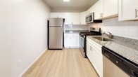Located at 1009 Warwick Drive in Aberdeen, Maryland, this single-floor home offers a clean, modern aesthetic with thoughtfully updated finishes throughout. Light wood luxury vinyl flooring runs through the main living areas, creating a cohesive and contemporary feel. The kitchen is a standout feature, equipped with stainless steel appliances including a refrigerator, gas range, and over-the-range microwave. White shaker-style cabinetry with brushed nickel hardware is complemented by granite countertops and a classic white subway tile backsplash, offering both style and functionality. The bathroom is finished with a white shaker vanity, white quartz countertop, and brushed nickel fixtures, lending a crisp, clean look. The spacious living area benefits from ample natural light and flows seamlessly through the layout. Bedrooms are carpeted in soft gray and feature windows that bring in natural light and views of the surrounding greenery. A louvered closet door and a wall thermostat are among the practical details noted throughout the home. The dollhouse view reveals a well-organized floor plan that maximizes the use of the single-level layout, making this home both functional and inviting.
