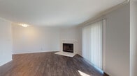 This single-floor residence offers a cohesive and well-appointed layout highlighted by dark hardwood-style flooring that runs throughout the main living areas and bedrooms. The living room serves as a central gathering space, featuring a marble-surround fireplace and a large sliding glass door fitted with vertical blinds that invites natural light. An adjoining area extends the living space, offering additional windows and a pass-through that connects to the kitchen, promoting an open, airy feel.

The kitchen is thoughtfully designed with gray shaker-style cabinetry, granite-style countertops, a white subway tile backsplash, and a full suite of stainless steel appliances including a refrigerator, electric range, and built-in microwave. A double stainless steel sink and ample counter space add functional appeal, while a window allows natural light to brighten the room.

The bedrooms are quiet and generously proportioned, each featuring the same rich hardwood-style flooring and closet access. The bathrooms are finished with gray cabinetry, granite countertops, and vessel sinks. The primary bathroom includes a walk-in shower, while the secondary bathroom offers a tub-shower combination. A hallway with attic access connects the spaces efficiently.