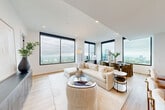 Located in the heart of Midtown Atlanta, this sophisticated 2-bedroom, 3-bathroom residence offers an elevated urban living experience with stunning panoramic views of the Atlanta skyline. The open-concept living, dining, and kitchen area is anchored by expansive floor-to-ceiling windows with bold black frames that flood the space with natural light and frame breathtaking city vistas. Light hardwood flooring flows throughout, complementing the clean, contemporary aesthetic.

The chef's kitchen is a standout feature, equipped with dark cabinetry, open wood shelving, a white quartz waterfall island with seating, and high-end stainless steel appliances with gold-tone hardware accents. A dedicated dining area sits adjacent, bathed in skyline views.

The generously sized primary bedroom captures city views through large windows and connects to a well-organized walk-in closet with built-in shelving and drawer systems. The primary bath features a dramatic marble-tiled walk-in shower with a glass enclosure and matte black fixtures. Additional bathrooms echo the modern design with stylish vanities and refined finishes.

The welcoming hallway entry is appointed with warm lighting and light wood floors. A dedicated laundry room, utility space, and three closets round out this thoughtfully designed, single-floor residence.