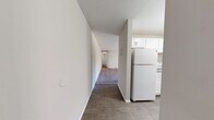 Located in Naugatuck, CT, this single-floor residence offers a well-organized layout across two bedrooms, one bathroom, and a combined kitchen and living area. The spacious living room is anchored by plush wall-to-wall carpeting, a textured ceiling, and a large sliding glass door that opens to a balcony, filling the room with natural light and providing outdoor views. Baseboard heating runs throughout, ensuring consistent warmth across the space.

The galley-style kitchen is efficiently designed with white shaker cabinets, granite-look countertops, a stainless steel sink, and white appliances including a stove and refrigerator. Wood-look flooring adds a clean, modern touch to this functional cooking space.

Both bedrooms are carpeted and neutrally toned, offering a quiet and comfortable atmosphere. The primary bedroom features a bi-fold closet, while the second bedroom benefits from a bright window with views of the surrounding area and baseboard heating along the walls.

The bathroom is clean and bright, featuring a white vanity, tiled tub-shower combination, wood-look flooring, and a window for natural ventilation. The overall aesthetic throughout the home is light, neutral, and move-in ready.
