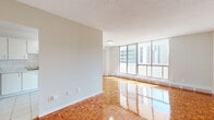 Located on the 9th floor at 565 Sherbourne Street in Toronto's vibrant St. James Town neighbourhood, this well-appointed 4-bedroom, 2-bathroom unit offers a practical and comfortable layout across a single floor. Gleaming parquet hardwood flooring flows throughout the living areas and all four bedrooms, lending warmth and a classic character to the space. The expansive living room is a standout feature, bathed in natural light through a wide bank of floor-to-ceiling windows that frame open city views of the Toronto skyline. The kitchen is clean and functional, finished with white cabinetry, white tile backsplash, light tile flooring, and stainless steel appliances including a fridge and range. It connects seamlessly to the living area, making it ideal for everyday living. The four bedrooms are well-proportioned, each featuring the same rich parquet flooring, with several rooms enjoying large windows and city views. One bedroom includes access to a dedicated closet. The two bathrooms are finished with light tile and clean white fixtures — one includes a full bathtub and shower combination, while the second offers a vanity with marble-style countertop. A hallway and closet complete the thoughtful layout of this roomy urban residence.