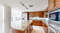 Located on the 28th floor at 215 N Pine St in Uptown Charlotte, this three-bedroom, two-bathroom residence offers an impressive high-rise living experience with sweeping panoramic views of the Charlotte skyline and surrounding cityscape. The open living and dining area is defined by expansive floor-to-ceiling windows on multiple sides, flooding the space with abundant natural light and showcasing dramatic city views. Polished marble-style tile flooring runs throughout the main living areas, lending an elegant and refined aesthetic.

The kitchen is well-appointed with rich wood cabinetry, granite countertops, stainless steel appliances including a built-in oven, microwave, and refrigerator, and a central island — all set atop the same distinctive marble-style flooring that flows through the living areas.

The bedrooms feature plush carpeting and ceiling fans, with the primary bedroom boasting its own set of floor-to-ceiling windows offering stunning views. The primary bathroom includes a deep soaking tub set within full tile surround and recessed lighting. A secondary bathroom features warm-toned tile flooring and granite vanity cabinetry. Bedrooms are equipped with sliding-door closets, and two dedicated closets provide ample storage throughout the unit.