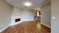 Located in the Acadia neighborhood of Lincoln, Nebraska, this single-story home offers a thoughtfully designed layout across two bedrooms and two bathrooms. The open-concept kitchen and living area serves as the heart of the home, with the kitchen showcasing dark espresso cabinetry, granite countertops, a classic subway tile backsplash, warm hardwood-style flooring, and a full suite of stainless steel appliances. Crown molding adds a refined touch throughout. The adjoining living room is anchored by a corner fireplace and continues the warm hardwood-style flooring, creating an inviting and cohesive space. The primary bedroom is generously sized, featuring plush carpet, a ceiling fan, a large window with outdoor views, and access to a dedicated walk-in closet with built-in shelving. The second bedroom is equally comfortable, with carpet and a window that brings in natural light. Both bathrooms are well-finished, with one featuring a full tub-shower combination with brushed nickel fixtures and granite-topped vanity. A dedicated laundry room includes a full-size washer and dryer with overhead shelving. The attached garage provides direct interior access, and the home sits within a well-maintained neighborhood with manicured lawns and a welcoming streetscape.