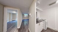 Located at 40 Tuxedo Crt in Toronto's Scarborough neighbourhood, this well-appointed one-bedroom unit offers a functional and comfortable layout across a single floor. The living room is bright and inviting, featuring large floor-to-ceiling sliding glass doors that flood the space with natural light and provide views of a lush, green outdoor setting enclosed by a wooden fence — creating a sense of privacy and tranquility. Consistent grey-toned laminate hardwood flooring runs throughout, lending the space a clean, modern aesthetic. Neutral warm beige and grey walls complement the flooring and contribute to a calm, cohesive ambiance. The kitchen is efficiently designed with white cabinetry and a dark countertop pass-through window that opens to the living and dining area, enhancing the open feel of the space. The bedroom is generously sized, benefiting from its own large window that brings in ample natural light and greenery views, along with baseboard heating for year-round comfort. A dedicated closet provides practical storage. Textured ceilings are present throughout, adding subtle character. This unit offers a balanced combination of natural light, thoughtful layout, and modern finishes in a well-established Toronto community.