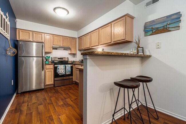 Cocina con acogedora barra de desayuno en Prentiss Pointe Apartments en Harrison Township, MI - Prentiss Pointe Apartments