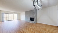 Located at 488 W Duarte Rd in Arcadia, CA, this well-designed 2-bedroom, 3-bathroom single-floor residence offers a thoughtfully laid-out floor plan with warm wood flooring running throughout. The open combined living and dining area serves as the heart of the home, anchored by a striking floor-to-ceiling whitewashed brick fireplace and illuminated by a modern industrial-style rectangular chandelier. Sliding glass doors lead to a balcony, filling the space with natural light. The kitchen features white cabinetry, stone-toned countertops, built-in appliances including a wall oven, and a window that brings in additional daylight. Both bedrooms are generously sized, each equipped with ceiling fans, vertical blinds, and ample closet space — with five closets total throughout the home. The primary bedroom offers a comfortable footprint with its own dedicated bathroom. The bathrooms are finished with clean white cabinetry, black hardware accents, framed mirrors, and glass-enclosed showers. Additional highlights include a dedicated laundry room and multiple hallways connecting the well-organized layout. Textured ceilings add a classic touch throughout this bright and functional Arcadia residence.