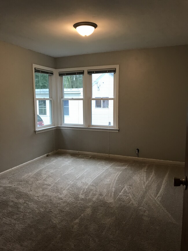 Main floor bedroom 10X13 with walk-in closet, new carpeting and corner windows with a beautiful view of the backyard. - 176 E 35th St