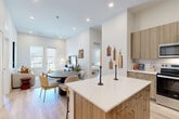 Located at 22624 E Radcliff Cir in Aurora, CO, this thoughtfully designed 2-bedroom, 2-bathroom single-floor home offers a clean, modern aesthetic with a warm, neutral palette throughout. Light wood-style flooring flows seamlessly across all rooms, complementing the crisp white walls and recessed lighting that keep the space bright and inviting.

The open-concept kitchen and living area serves as the heart of the home. The kitchen is well-appointed with floor-to-ceiling warm wood cabinetry, stainless steel appliances including a range, microwave, dishwasher, and refrigerator, white quartz countertops, a tiled backsplash, and a central island with bar seating. The adjoining living and dining area benefits from large windows and a glass door that fill the space with natural light and provide outdoor views.

A practical entry hallway features built-in bench seating and wall hooks, leading into the main living space. Both bedrooms are serene and comfortably scaled, with the primary bedroom offering a closet and natural light from a window. The bathrooms mirror the home's modern style, featuring wood-tone vanities, white quartz counters, and tub-shower combinations with tile surrounds. A dedicated closet provides additional storage.