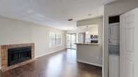 Located at 400 Marion Pugh Dr in College Station, TX, this single-floor unit offers a practical and comfortable layout with consistent hardwood-style flooring throughout. The living room is a standout space, featuring a tile-surround fireplace and large windows that allow ample natural light to filter in, alongside a sliding glass door that opens to a balcony with outdoor views. The open layout connects seamlessly to the kitchen, which is well-appointed with white cabinetry, granite-style countertops, stainless steel appliances including a range, microwave, and refrigerator, and a peninsula with pendant lighting that doubles as a breakfast bar. The bedrooms are comfortably sized, each with hardwood-style flooring, blinds for privacy, and ceiling fans for added comfort. Closets provide convenient storage. The bathrooms are finished with white vanity cabinetry, granite-style countertops, large mirrors, and a tub-shower combination. Textured ceilings are present throughout the unit. The overall ambiance is clean, neutral, and move-in ready, offering a functional living environment in a well-situated College Station location.