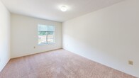 Located at 350 Snyder Way in Radcliff, Kentucky, this single-floor, 2-bedroom, 1-bathroom residence offers a practical and comfortable layout. The interior features warm neutral tones throughout, with wall-to-wall carpeting across the living areas and bedrooms, complemented by clean white walls and wood-toned trim and cabinetry.

The kitchen opens to the living area via a pass-through counter with warm wood-panel detailing, creating a connected and functional space. The kitchen is equipped with essential appliances including a range and refrigerator, with overhead cabinetry providing ample storage.

Both bedrooms are carpeted and well-proportioned. The primary bedroom features a set of wood bi-fold closet doors and a window overlooking the outdoors, bringing in natural light and views of the surrounding greenery. The second bedroom also includes a dedicated closet and a window, maintaining a bright and airy feel. A hallway connects the bedrooms, with additional closet storage accessible along the corridor.

The bathroom is finished with tile flooring, a vanity with wood-accented cabinetry, a tub/shower combination, and clean white fixtures throughout. The overall design is straightforward and functional, offering a comfortable living environment in a residential Radcliff neighborhood.
