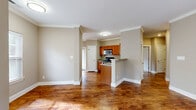 Located at 1317 Scottsville Rd in Bowling Green, Kentucky, this single-story, 3-bedroom, 2-bathroom home offers a well-organized and functional layout. The open-concept living and kitchen area serves as the heart of the home, featuring warm hardwood-style flooring, neutral taupe walls, and crown molding that adds a refined touch. Natural light flows in through multiple windows dressed with white blinds, creating a bright and welcoming atmosphere throughout.

The kitchen is equipped with stainless steel appliances — including a range, microwave, and dishwasher — complemented by rich wood cabinetry and a convenient breakfast bar peninsula. A front entryway with large windows further enhances the home's natural light and curb appeal.

The bedrooms are carpeted for comfort, with the spacious primary bedroom featuring a ceiling fan, a window with outdoor views, and access to a walk-in closet outfitted with wire shelving. The bathrooms include hardwood-style flooring, wood vanity cabinetry with countertop sinks, and a tub/shower combination. Additional closets throughout provide ample storage.

An attached garage with an automatic opener and windowed door completes this practical and well-appointed home.