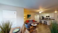 This single-floor residence offers a thoughtfully designed layout that balances comfort and functionality across its living spaces. The open-concept living and dining area serves as the heart of the home, featuring light wood-look flooring, a ceiling fan with integrated lighting, and a wall-mounted flat-screen television. The space flows seamlessly into a dedicated dining area illuminated by natural light from large windows fitted with vertical blinds, providing both brightness and privacy.

The kitchen is equipped with white shaker-style cabinetry, dark countertops, and a full suite of stainless steel appliances, including a refrigerator, electric range, and microwave. A breakfast bar with seating adds casual dining functionality, while track lighting overhead ensures a well-lit workspace.

Two bedrooms provide comfortable retreats, each featuring the same wood-look flooring, ceiling fans, and windows with horizontal blinds that allow for natural light. Both rooms are generously proportioned and offer a calm, restful atmosphere.

The bathroom is finished with neutral tile flooring and includes a full tub-shower combination with clean white tile surround. Throughout the residence, a consistent coastal-inspired aesthetic is reflected in the light color palette and thoughtful design details, creating a cohesive and inviting living environment.