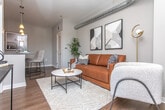 Located in the Brookwood Valley neighborhood of Atlanta, GA, this single-floor unit offers a thoughtfully designed layout with modern finishes throughout. Rich hardwood-style flooring flows consistently across all areas, creating a cohesive and polished aesthetic.

The kitchen is well-appointed with light wood cabinetry, a subway tile backsplash, stainless steel appliances, and a central island featuring a dark quartz countertop with pendant lighting above — ideal for casual dining or meal prep. Track lighting adds both functionality and ambiance to the space.

The living area showcases an industrial-modern character, highlighted by an exposed cylindrical ductwork detail along the ceiling, neutral gray walls, and ample room for comfortable furnishings. The space connects seamlessly to the rest of the unit.

The bedroom is a restful retreat with a large window that invites natural light, a ceiling fan, and a double-door closet offering generous storage. Neutral tones throughout contribute to a calm, inviting atmosphere.

The bathroom is finished with clean white subway tile in the walk-in shower, a frameless sliding glass enclosure with brushed nickel hardware, a mosaic tile shower floor, and wood-look flooring — balancing style with practicality. A paneled barn-style door adds a distinctive design touch to the space.