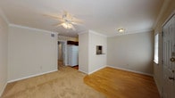This single-floor residence offers a practical and well-organized layout designed for comfortable everyday living. The entryway welcomes you with warm hardwood flooring that extends into the living and dining areas, while plush carpeting adds comfort to the bedroom and lounge spaces. Crown molding runs throughout the unit, lending a clean, finished look to each room.

The open living area is bright and inviting, featuring a ceiling fan with integrated lighting and a seamless transition between the carpeted lounge space and the hardwood floor zone. A built-in pass-through niche connects the living area to the kitchen, adding a convenient and functional architectural detail.

The kitchen is efficiently designed in a galley configuration, outfitted with rich, dark wood cabinetry, dark granite-style countertops, a stainless steel sink, and white appliances including a range, microwave, and refrigerator. Hardwood flooring continues underfoot, complementing the cabinetry's warm tones.

The bedroom is generously proportioned, featuring soft carpeting, a ceiling fan, a window allowing in natural light, and access to a closet. The bathroom includes a full tub-and-shower combination with a clean, white surround. Throughout the unit, neutral wall tones and white trim create a cohesive, move-in-ready aesthetic.