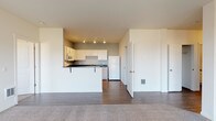 This single-floor residence in Post Falls, Idaho offers a thoughtfully designed layout that balances comfort and functionality. The open-concept living area is anchored by a classic white fireplace mantle and flows seamlessly into the kitchen, which is set apart by a raised breakfast bar. Flooring transitions from plush carpet in the living areas to durable wood-style planks in the kitchen and wet areas. The kitchen is well-appointed with white cabinetry, dark granite-style countertops, a full suite of white appliances including an electric range, built-in microwave, dishwasher, and refrigerator, all illuminated by track lighting overhead. The bedrooms are carpeted and receive generous natural light through large windows, with views of the surrounding neighborhood and treeline. A spacious walk-in closet with wire shelving provides substantial storage in the primary suite. Two full bathrooms serve the unit — one featuring a soaking tub and shower combination, the other a stand-alone shower — both with white cabinetry and dark countertops. A dedicated in-unit laundry room accommodates a full-size washer and dryer with additional overhead shelving. Baseboard heating and multiple windows throughout ensure year-round comfort and brightness.