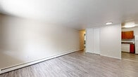 Located at 4 Farnsworth Drive in Slingerlands, New York, this single-floor, three-bedroom, one-bathroom residence offers a practical and efficiently organized layout. The interior features a neutral color palette throughout, with light wood-look vinyl flooring extending across the main living areas and hallway, creating a cohesive and clean aesthetic.

The living area is open and simply designed, featuring baseboard heating, a wall-mounted air conditioning unit, and a window that provides natural light and views of the surrounding exterior. The kitchen is equipped with warm honey-toned wood cabinetry, dark granite-style countertops, a stainless steel sink, a dishwasher, a white refrigerator, and a range, offering a functional cooking space.

The three bedrooms are carpeted, contributing a softer feel to the private areas of the home. The spacious primary bedroom receives natural light through a large window overlooking wooded greenery. Additional bedrooms include closet storage with sliding doors fitted with built-in shelving and hanging rods. The shared bathroom features classic white tile surrounding a full bathtub and shower combination.

A connecting hallway links the rooms, providing a straightforward and efficient flow throughout the home.