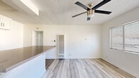 This 490 square foot apartment in Alhambra, CA offers a thoughtfully designed living space with one bedroom and one bathroom. The interior boasts a modern aesthetic with a predominant white color scheme, creating a bright and airy atmosphere throughout. The kitchen is a standout feature, showcasing sleek white cabinetry, stainless steel appliances, and a subway tile backsplash. A spacious countertop doubles as a breakfast bar, enhancing the functionality of the space. The bedroom, measuring 160 square feet, is equipped with a modern ceiling fan and ample natural light from the window. Light-toned wood-look flooring runs throughout the apartment, adding warmth and continuity. The bathroom features a clean, minimalist design with a window for natural light. The open floor plan maximizes the use of space, making the apartment feel larger than its actual square footage. This property is ideal for those seeking a contemporary, low-maintenance living space in an urban setting.