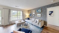 Located at One Avalon Drive in Peabody, Massachusetts, this well-appointed 2-bedroom, 2-bathroom residence offers a thoughtfully designed single-floor layout that balances comfort and style. Warm hardwood-style flooring flows consistently throughout the home, creating a cohesive and inviting atmosphere.

The living room serves as a central gathering space, highlighted by a striking exposed brick accent wall that adds texture and character. Large windows invite an abundance of natural light and provide pleasant views of the surrounding greenery.

The kitchen is outfitted with crisp white shaker cabinetry, stone countertops, a classic subway tile backsplash, and stainless steel appliances — offering both functionality and clean, modern aesthetics. Adjacent to the kitchen, the bright dining area is surrounded by oversized windows framing peaceful outdoor views of mature trees and landscaping, making it an ideal spot for everyday meals or entertaining.

The primary bedroom is generously sized, featuring large windows with garden views and easy access to a dedicated bathroom. The second bedroom is equally comfortable and well-lit. Both bathrooms are finished with clean, classic tile work, including a tiled tub-shower combination. A private balcony accessible from the unit rounds out this residence with a serene outdoor retreat overlooking lush, landscaped grounds.