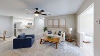 Located at 1 Saint George Boulevard in Savannah, GA, this well-appointed 2-bedroom, 2-bathroom residence offers a comfortable and functional single-floor layout. The open-concept living area is bright and inviting, featuring wood-look flooring, a ceiling fan with light fixture, and a large window that draws in natural light. The living room flows seamlessly into the dining area, which comfortably accommodates a dining table, and into the kitchen beyond. The kitchen is outfitted with white shaker-style cabinetry, granite-look countertops, stainless steel appliances including a range and built-in microwave, and a dishwasher — all set on easy-care hard-surface flooring. Both bathrooms include a tub/shower combination, wood-look tile flooring, and granite vanity tops with white cabinetry. The bedrooms are carpeted and generously sized, with the primary bedroom offering direct access to a walk-in closet equipped with wire shelving systems and basket storage. A second well-proportioned closet serves the additional bedroom. Neutral warm-gray tones throughout the home create a cohesive, calming aesthetic that suits a variety of décor styles.