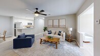 Located at 1 Saint George Boulevard in Savannah, GA, this well-appointed 2-bedroom, 2-bathroom residence offers a comfortable and functional single-floor layout. The open-concept living area is bright and inviting, featuring wood-look flooring, a ceiling fan with light fixture, and a large window that draws in natural light. The living room flows seamlessly into the dining area, which comfortably accommodates a dining table, and into the kitchen beyond. The kitchen is outfitted with white shaker-style cabinetry, granite-look countertops, stainless steel appliances including a range and built-in microwave, and a dishwasher — all set on easy-care hard-surface flooring. Both bathrooms include a tub/shower combination, wood-look tile flooring, and granite vanity tops with white cabinetry. The bedrooms are carpeted and generously sized, with the primary bedroom offering direct access to a walk-in closet equipped with wire shelving systems and basket storage. A second well-proportioned closet serves the additional bedroom. Neutral warm-gray tones throughout the home create a cohesive, calming aesthetic that suits a variety of décor styles.