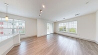 This well-designed two-bedroom, two-bathroom residence in Andover, MA offers a thoughtful layout across a single floor, delivering a comfortable and modern living experience. The bright living room features wood-style plank flooring, large windows that flood the space with natural light, and sliding glass doors that open directly onto a private balcony with tree-lined views. A built-in recessed niche adds a distinctive architectural touch to the living area. The kitchen is equipped with stainless steel appliances, rich wood-toned cabinetry reaching to the ceiling, a stylish tile backsplash, light quartz countertops, and a center island, all complemented by an oversized window. A welcoming hallway connects the living spaces to the private quarters, where both bedrooms offer plush carpeting and generous natural light. The primary bedroom includes an en-suite bathroom finished with large-format marble-look tile flooring, warm wood vanity cabinetry, and access to a spacious walk-in closet outfitted with wire shelving. A second full bathroom and four closets throughout the home provide ample storage. A dedicated laundry area and utility room add everyday convenience, rounding out this well-appointed residence.