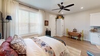 Located at 1718 Fairbanks Dr in Barling, Arkansas, this efficiently designed one-bedroom, one-bathroom space offers a well-curated interior that maximizes its compact footprint without sacrificing style or functionality. The layout flows naturally across a single floor, connecting each room with a cohesive farmhouse-inspired aesthetic characterized by warm wood-look flooring, neutral tones, and thoughtful finishing touches throughout.

The bedroom features a ceiling fan with recessed lighting, large windows with blinds that invite ample natural light, and a welcoming atmosphere accentuated by rustic décor elements including shutter-style wall accents and vintage-inspired furnishings. A white armoire provides practical storage within the space.

The kitchen showcases white shaker-style cabinetry extending to the ceiling, striking granite countertops, a decorative tile backsplash, and black hardware accents — offering generous counter and storage space despite the overall compact scale of the unit.

The bathroom is finished with large-format neutral tiles, a walk-in shower with matte black rod fixtures, a white vanity topped with granite, and a gold-framed mirror, lending a polished, spa-like quality. Recessed lighting throughout maintains a bright, clean ambiance across all rooms.