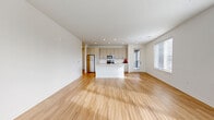 Located at 311 W 22nd St in Kansas City, MO, this thoughtfully designed single-story home offers three bedrooms and two bathrooms within a well-appointed, modern floor plan. The heart of the home is a bright, open-concept living, dining, and kitchen area unified by light hardwood flooring and crisp white walls. The kitchen is a standout feature, showcasing white shaker-style cabinetry, stainless steel appliances, white subway tile backsplash, light countertops, and a central island with a built-in sink — ideal for both cooking and entertaining. Recessed lighting illuminates the space, while large windows invite abundant natural light into the living area. A hallway connects the private quarters, where the bedrooms feature plush carpeting and generous closet space, including walk-in closets with wire shelving systems. The primary bedroom offers a comfortable footprint with its own access to storage. The bathrooms are finished with clean, modern aesthetics — one featuring a dual-sink vanity with white cabinetry, subway-tiled tub surround, and hardwood-style flooring. Additional utility and laundry rooms provide practical convenience. The home's consistent use of neutral tones and contemporary hardware creates a cohesive, move-in-ready atmosphere throughout.