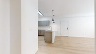 Located at 11803 NE 124th Ave in Vancouver, WA, this thoughtfully designed one-bedroom, one-bathroom unit offers a clean, modern aesthetic across a single floor. Light-toned hardwood flooring flows seamlessly throughout the space, creating a bright and cohesive feel. The open-concept kitchen is a standout feature, showcasing gray shaker-style cabinetry, white quartz countertops, a peninsula with an undermount sink, and a full suite of stainless steel appliances including a refrigerator, gas range, and over-the-range microwave. Sleek pendant lighting adds a contemporary touch above the kitchen peninsula, complemented by a skylight that draws in additional natural light. The living room is welcoming and airy, with a glass-paned exterior door and large window that allow ample sunlight to fill the space. The bedroom is comfortably sized, featuring a bright window with blinds, light-filled walls, and a wall-mounted mini-split system for year-round climate control. The bathroom is finished with a gray shaker vanity, white quartz countertop, undermount sink, and a large frameless mirror, all accented with brushed gold hardware. Clean white walls and a neutral palette throughout give the space a fresh, move-in-ready appeal.