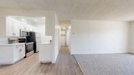 Located at 23825 Anza Ave in Torrance, California, this thoughtfully updated one-bedroom, one-bathroom residence offers a comfortable and functional single-floor layout. The open living area is generously sized, featuring plush carpet flooring, a ceiling fan, a textured ceiling, and a sliding glass door with vertical blinds that floods the space with natural light and provides access to an outdoor balcony. The galley-style kitchen is a standout, boasting white shaker cabinetry with matte black hardware, stone-look countertops, a mosaic tile backsplash, a matte black undermount sink, and a full suite of stainless steel appliances including a refrigerator, electric range, microwave, and dishwasher. Wood-look luxury vinyl plank flooring ties the kitchen and hallway together seamlessly. The primary bedroom offers comfortable carpet flooring, a natural light window, a textured ceiling, and a mirrored sliding closet with a built-in rod. The bathroom is tastefully finished with a white vanity, stone-look countertop, matte black fixtures and hardware, wood-look tile flooring, and a clean, bright atmosphere. A connecting hallway completes the efficient layout of this well-designed Torrance residence.