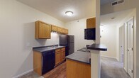 Located at 785 Cross Pointe Rd in Gahanna, Ohio, this single-floor unit offers a well-organized, open-concept layout designed for comfortable everyday living. The galley-style kitchen is efficiently arranged with warm oak cabinetry lining both walls, dark countertops, hardwood-style flooring, and a full suite of black appliances including a refrigerator, electric range with overhead microwave, and dishwasher. A double-basin sink and ample upper and lower cabinet storage round out the kitchen's functional design. A peninsula counter connects the kitchen to the main living area, creating a natural flow between the two spaces. The living room is generously proportioned, featuring plush carpeting and a sliding glass door that draws in natural light and provides access to an outdoor area. Neutral wall tones throughout lend a clean, versatile backdrop. The bedroom is carpeted, well-lit by a window with exterior views, and offers a quiet, comfortable retreat. The bathroom is finished with matching oak cabinetry, a dark countertop vanity, a lighted mirror, hardwood-style flooring, and a full tub and shower combination. A hallway connects the primary living spaces to the bedroom and bathroom, contributing to the unit's intuitive and practical floor plan.