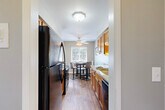Located at 1245 Astor Dr in Ann Arbor, MI, this well-appointed one-bedroom, one-bathroom unit offers a thoughtfully organized single-floor layout. The galley-style kitchen is a standout feature, showcasing warm honey-toned cabinetry, granite countertops, and black appliances including a refrigerator, electric range, built-in microwave, and dishwasher. Hardwood-style flooring runs through the kitchen and dining area, where a ceiling fan and a window provide natural light and ventilation. The living room is carpeted and generously proportioned, featuring crown molding, large windows with views of surrounding greenery, and ample wall space. The bedroom offers comfortable carpeted flooring, a closet, and a window that lets in natural light. The full bathroom includes a granite-topped vanity with warm wood cabinetry, a tub/shower combination with a window above, and tile flooring. Two hallways connect the space efficiently. Throughout the unit, a neutral gray and beige color palette creates a calm, cohesive ambiance, while the consistent access to natural light through multiple windows enhances the overall sense of openness and livability.