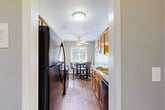 Located at 1245 Astor Dr in Ann Arbor, MI, this well-appointed one-bedroom, one-bathroom unit offers a thoughtfully organized single-floor layout. The galley-style kitchen is a standout feature, showcasing warm honey-toned cabinetry, granite countertops, and black appliances including a refrigerator, electric range, built-in microwave, and dishwasher. Hardwood-style flooring runs through the kitchen and dining area, where a ceiling fan and a window provide natural light and ventilation. The living room is carpeted and generously proportioned, featuring crown molding, large windows with views of surrounding greenery, and ample wall space. The bedroom offers comfortable carpeted flooring, a closet, and a window that lets in natural light. The full bathroom includes a granite-topped vanity with warm wood cabinetry, a tub/shower combination with a window above, and tile flooring. Two hallways connect the space efficiently. Throughout the unit, a neutral gray and beige color palette creates a calm, cohesive ambiance, while the consistent access to natural light through multiple windows enhances the overall sense of openness and livability.