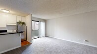 Located at 2185 Chatsworth Blvd in San Diego's coastal Point Loma neighborhood, this efficiently designed single-floor unit makes smart use of its compact footprint. The open-plan living, dining, and kitchen area forms the heart of the space, bathed in natural light through a sliding glass door that leads to a private balcony. Soft, neutral-toned carpeting extends throughout the living and hallway areas, complementing the textured ceiling and clean white walls for a bright, cohesive feel. The kitchen is well-appointed with striking dark granite-style countertops that contrast elegantly against crisp white cabinetry, a stainless steel refrigerator, and a cozy breakfast bar. Warm hardwood-style flooring anchors the kitchen, adding a welcoming touch. A connecting hallway leads to two bathrooms, both featuring clean white finishes and hardwood-style flooring, offering practical functionality. A dedicated closet provides valuable storage. The overall layout flows intuitively, maximizing every square foot while maintaining an open, airy ambiance. This unit offers a comfortable, move-in-ready space in a well-situated San Diego neighborhood close to the coast.